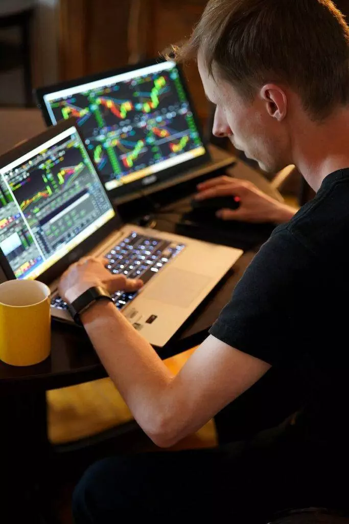 man sitting in front of the laptop trading stocks