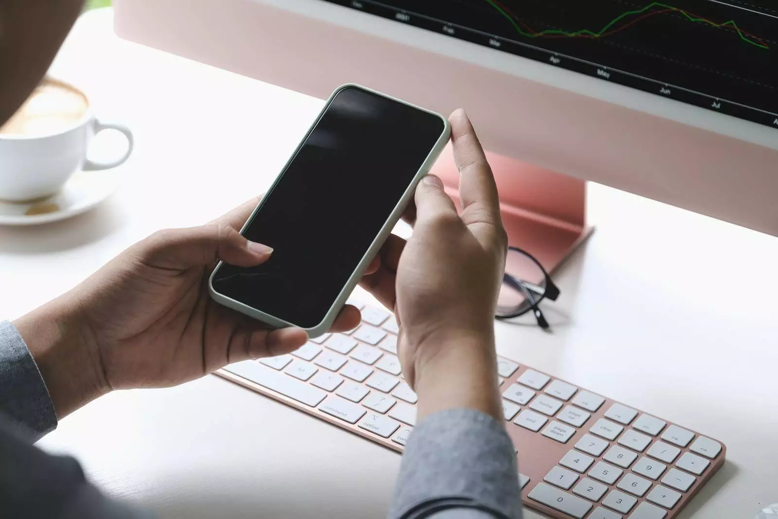 Self-Employed Man Are Using Mobile Phone And Computer Laptop To Trade Stocks For Profit