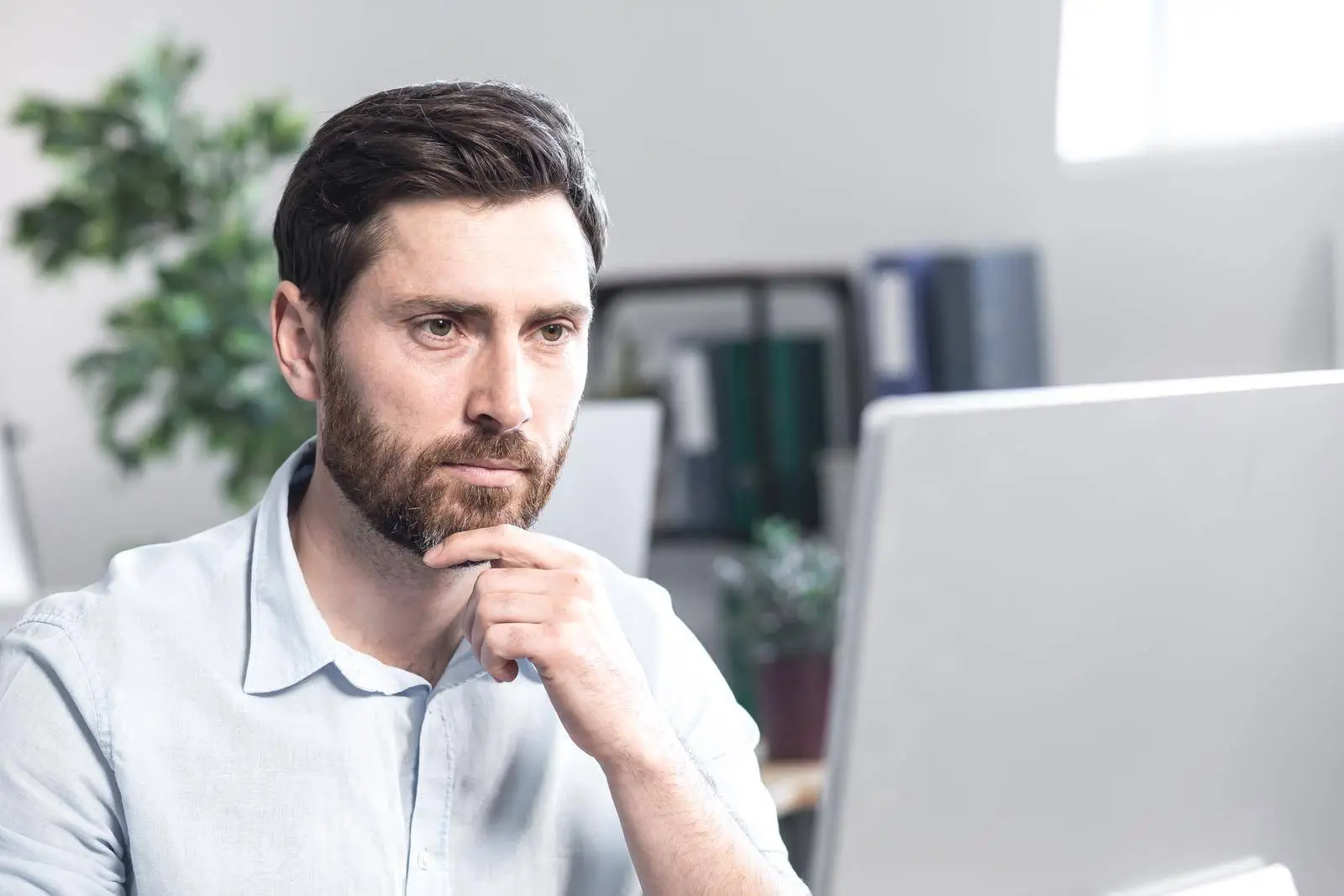 Confident Business Man Stocks Broker Sitting In Front Of Monitor Screen In Office Analyzing