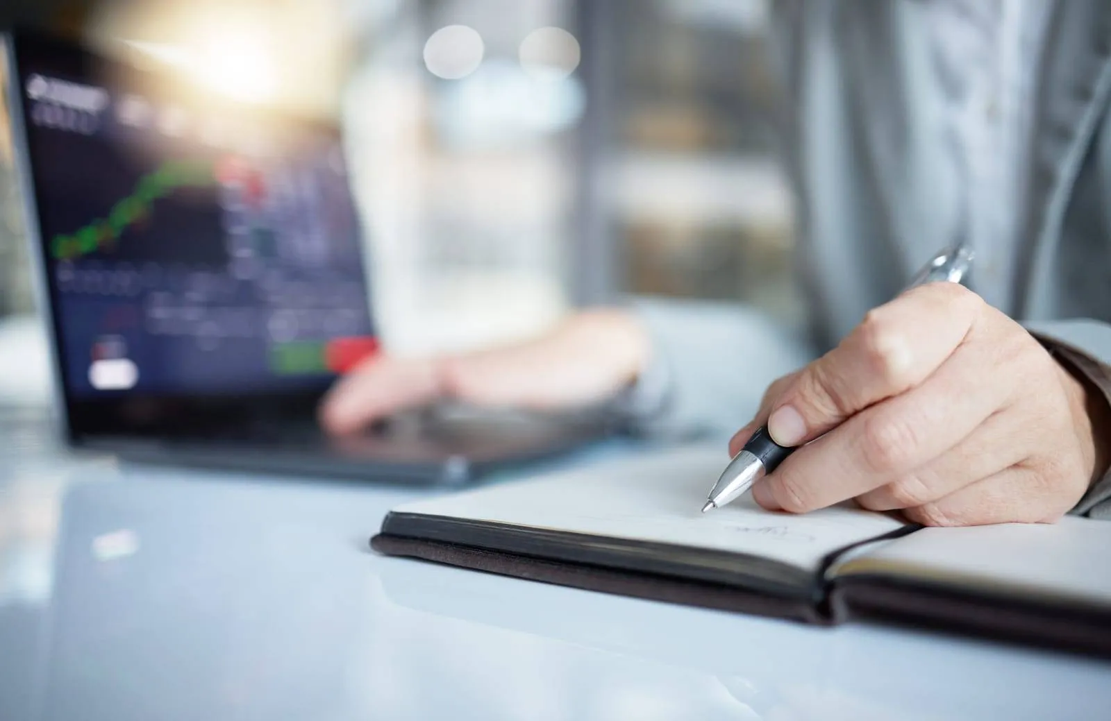 How to Start a Stock Trading Business from Home: Mastering Active Trading 4 Trader, Hands And Writing Notes In Book By Laptop On Stock Market Chart Or Graph Statistics For Trading At The Office.