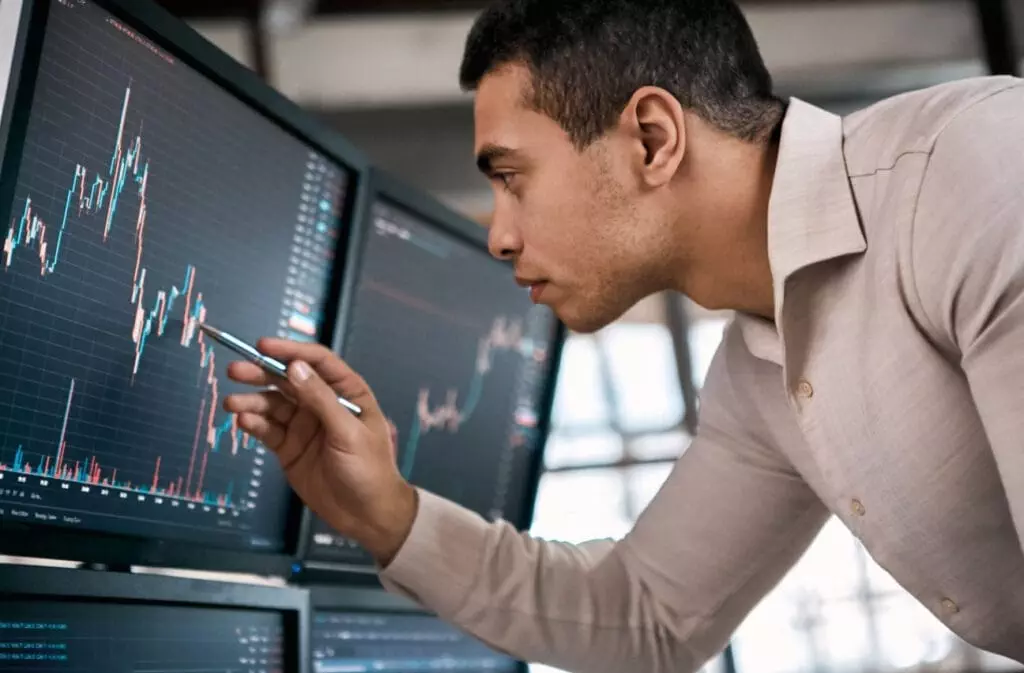 A man in suit decoding and understading the Candlestick pattern.