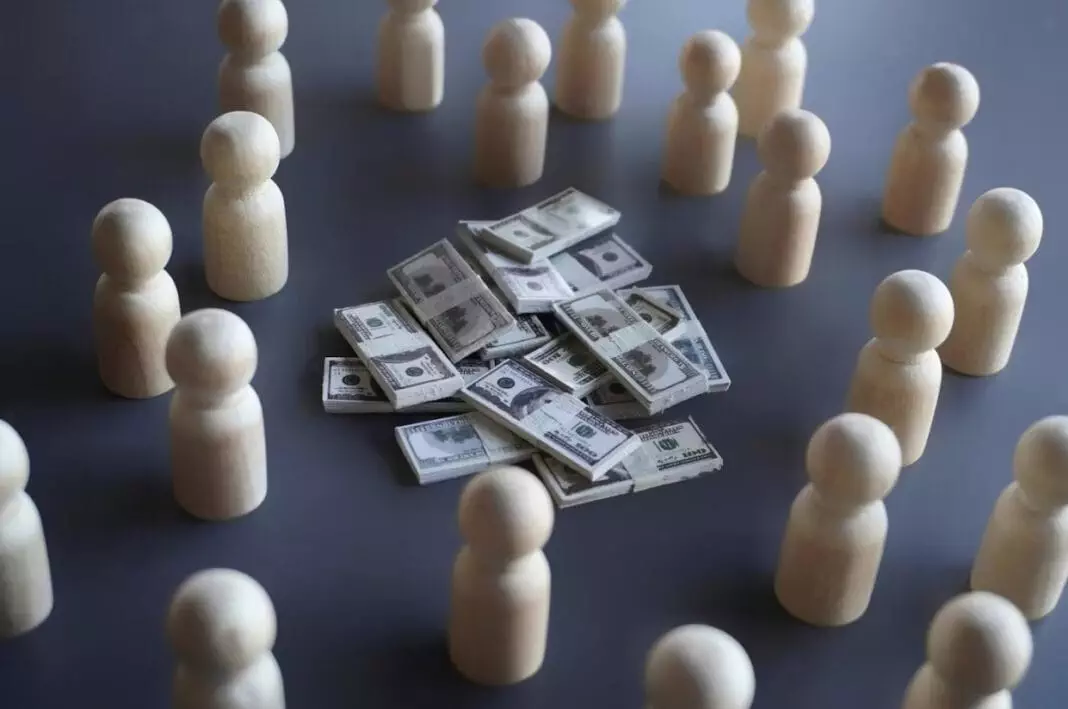 Wooden pawns encircling a stak of play dollar money